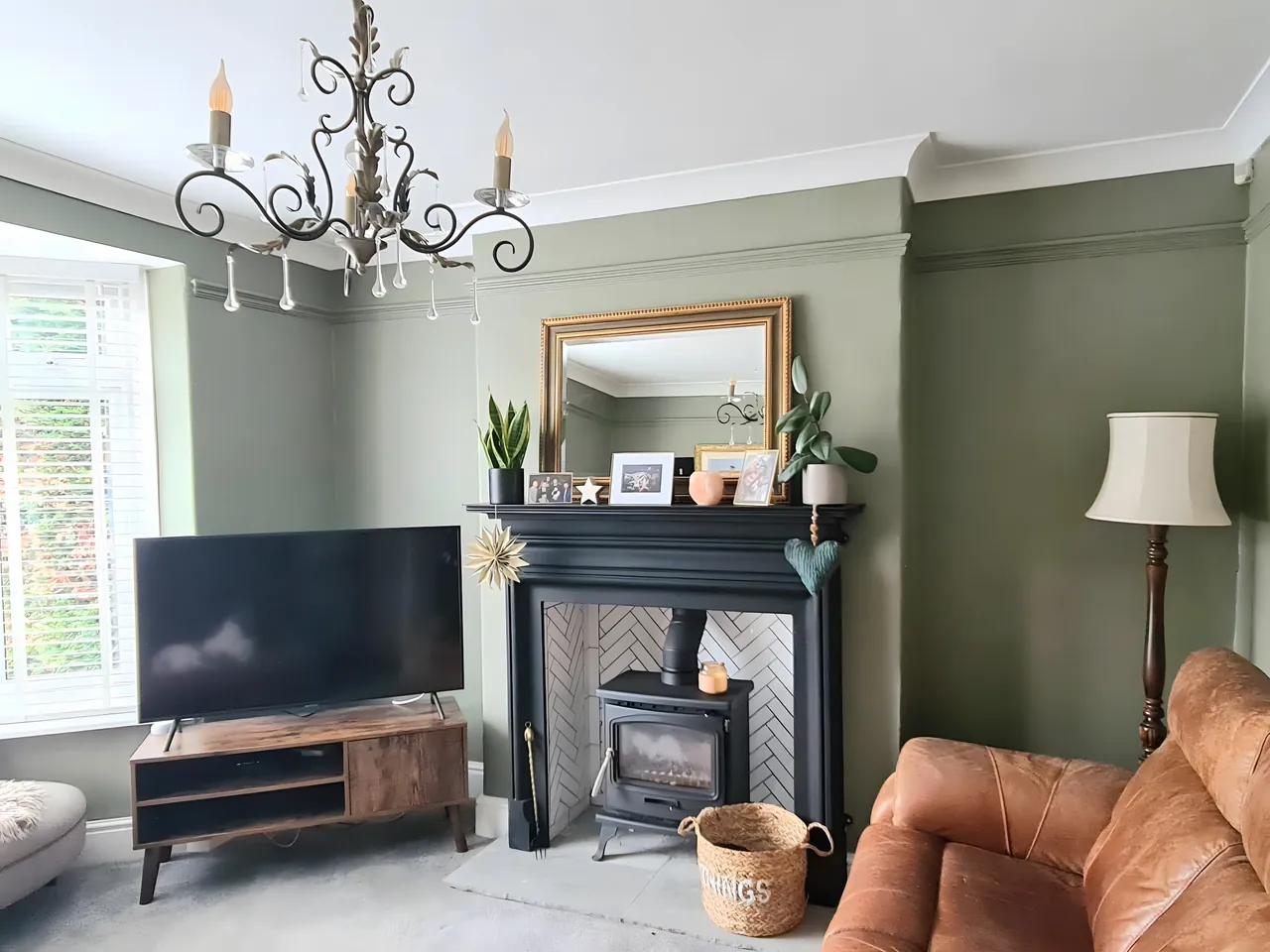 Freshly painted living room with green walls and a black fireplace